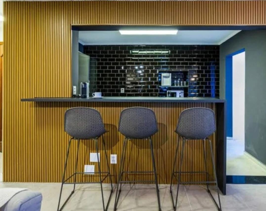 Bar com painel ripado e bancada preta